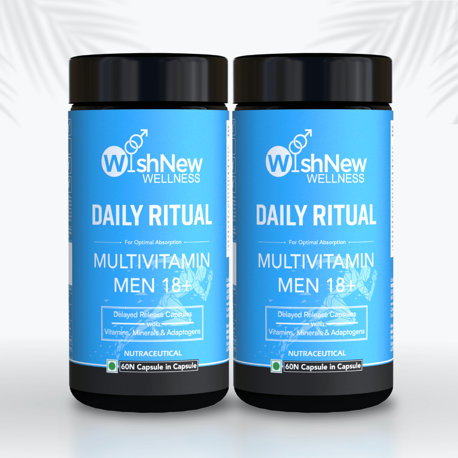 Image featuring two bottles of WishNew Wellness Daily Ritual Multivitamin Men 18+, displayed side by side. The vibrant blue packaging highlights key product features such as delayed-release capsules with vitamins, minerals, and adaptogens. The clean white background with faint palm leaf accents adds a natural and fresh aesthetic.